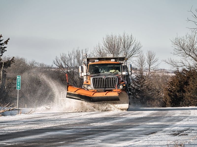 Snow plow truck clearing a snowy road