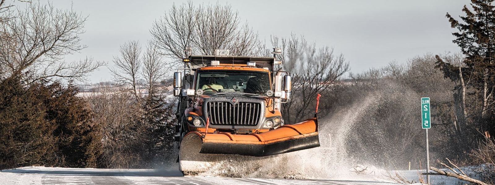 Snow plow truck clearing a snowy road